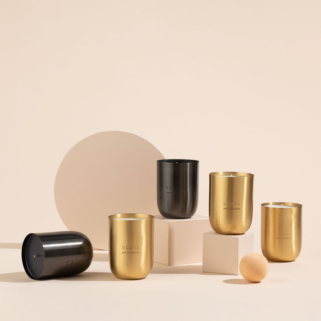 Brass and black candles on neutral plinths