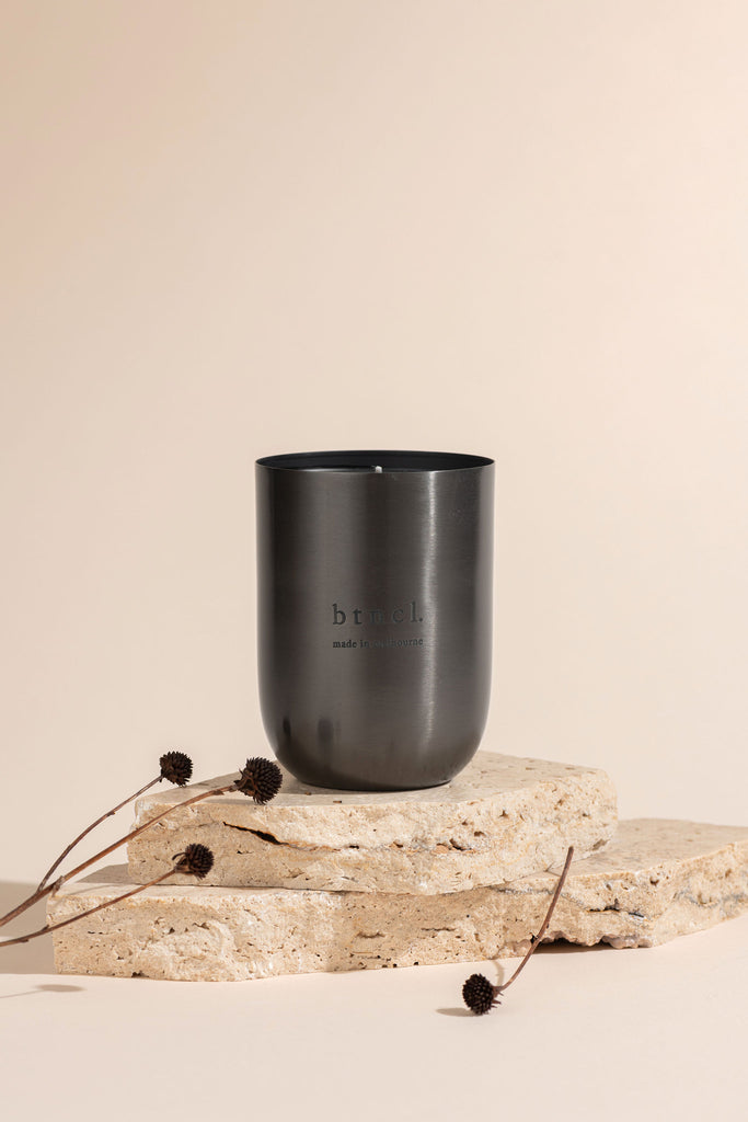 Black vessel candles on travertine slab