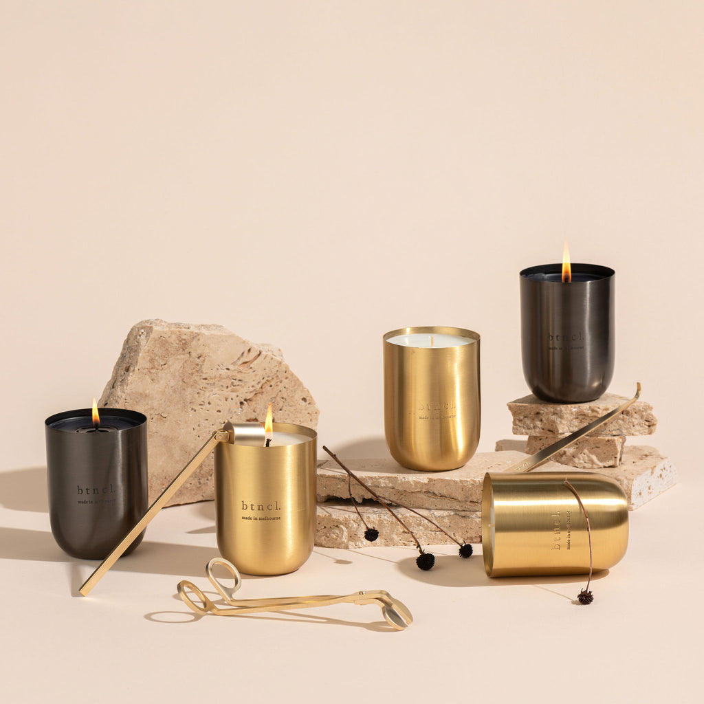 Brass and black btncl candles positioned on travertine slabs