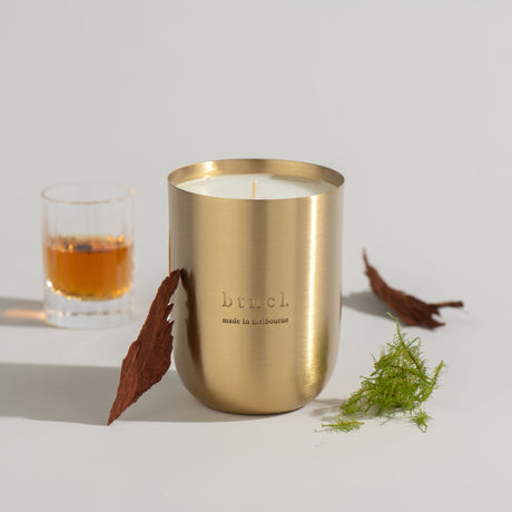 Sequoia candle with glass of whiskey and bark