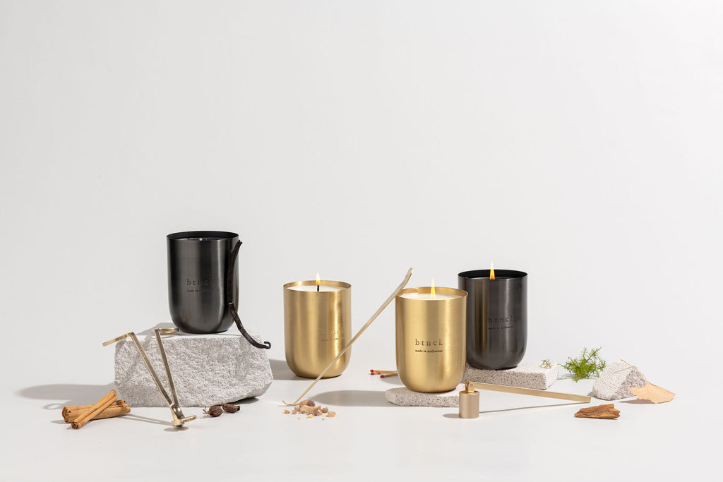 Black and brass candles on travertine slabs with accessories