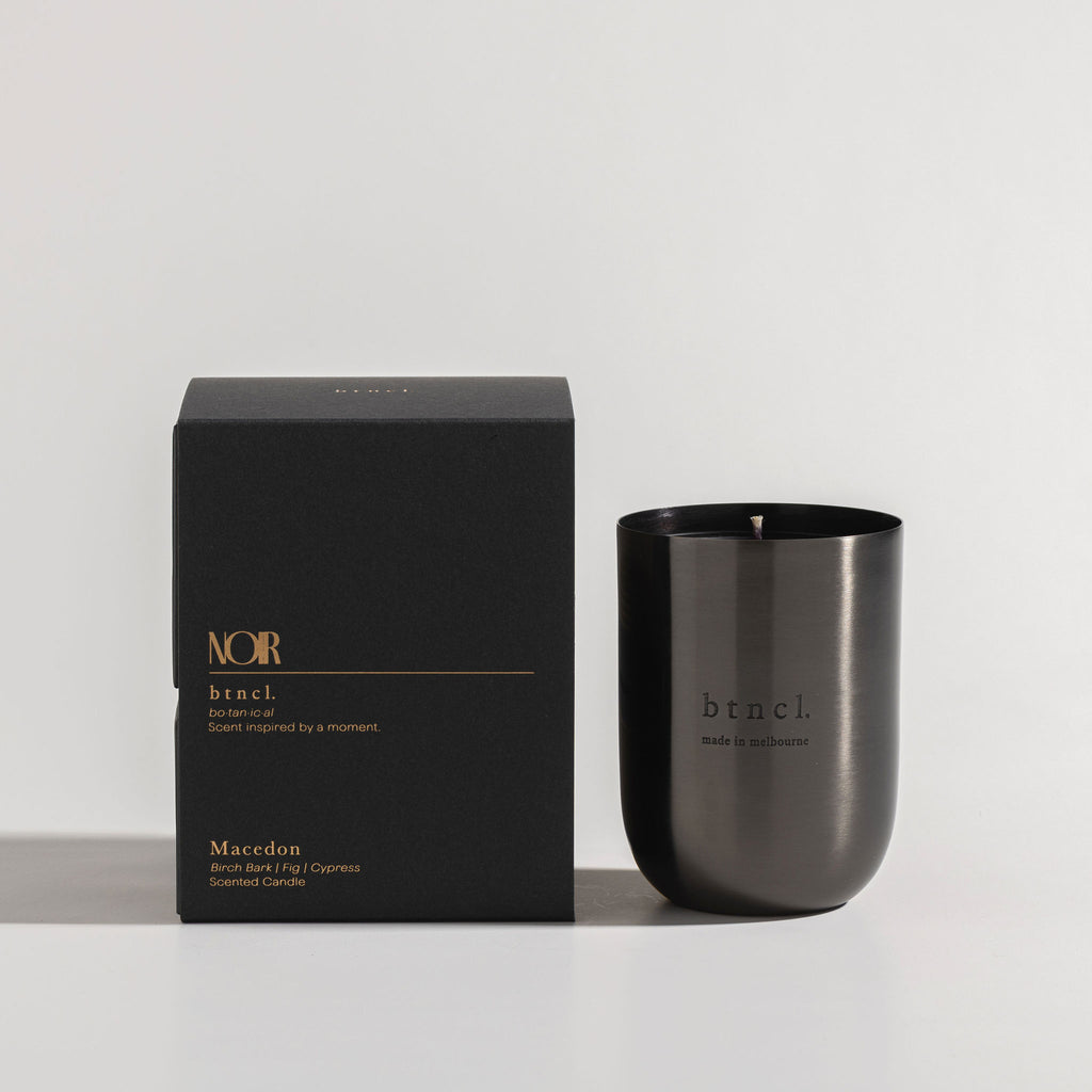 Black macedon candle next to black packaging