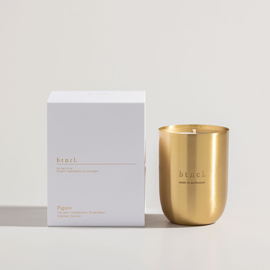 Brass figaro candle next to white packaging
