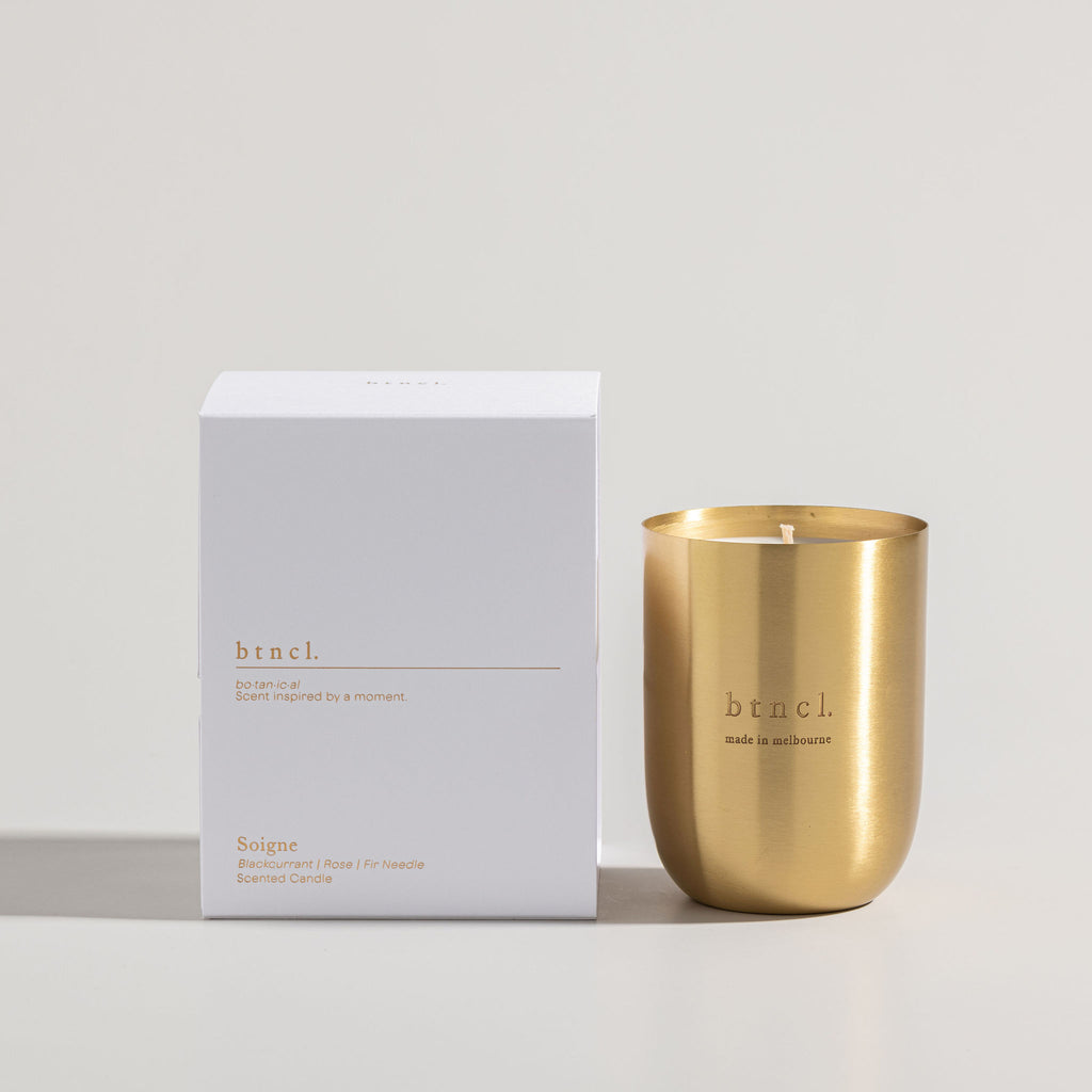Soigne candle next to luxurious white packaging